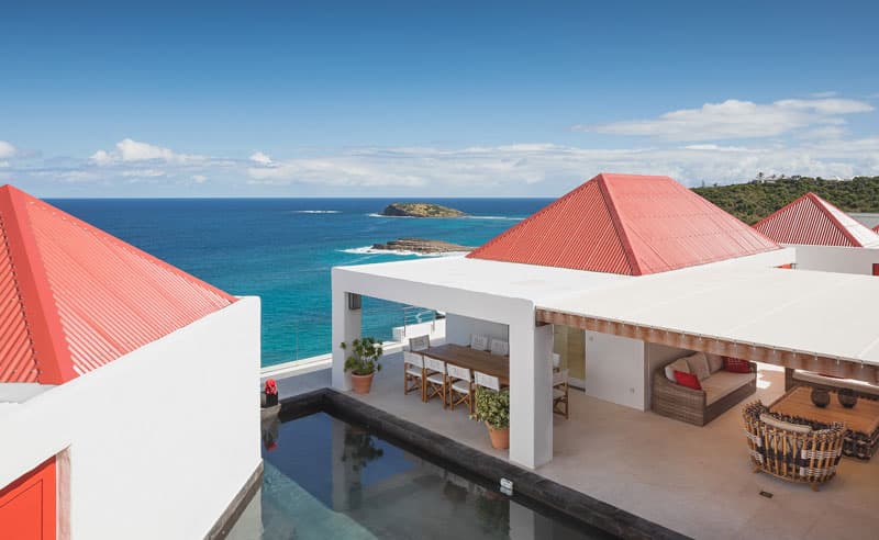 View of the blue ocean, swimming pool, outdoor dining table and roof of Elle Villa from the top